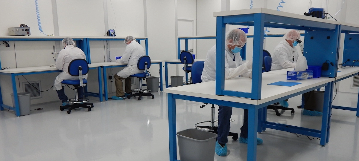 A group of people in white lab coats working in a lab