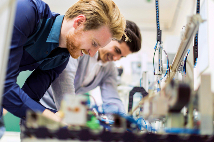 Two men working on a machine in a factory