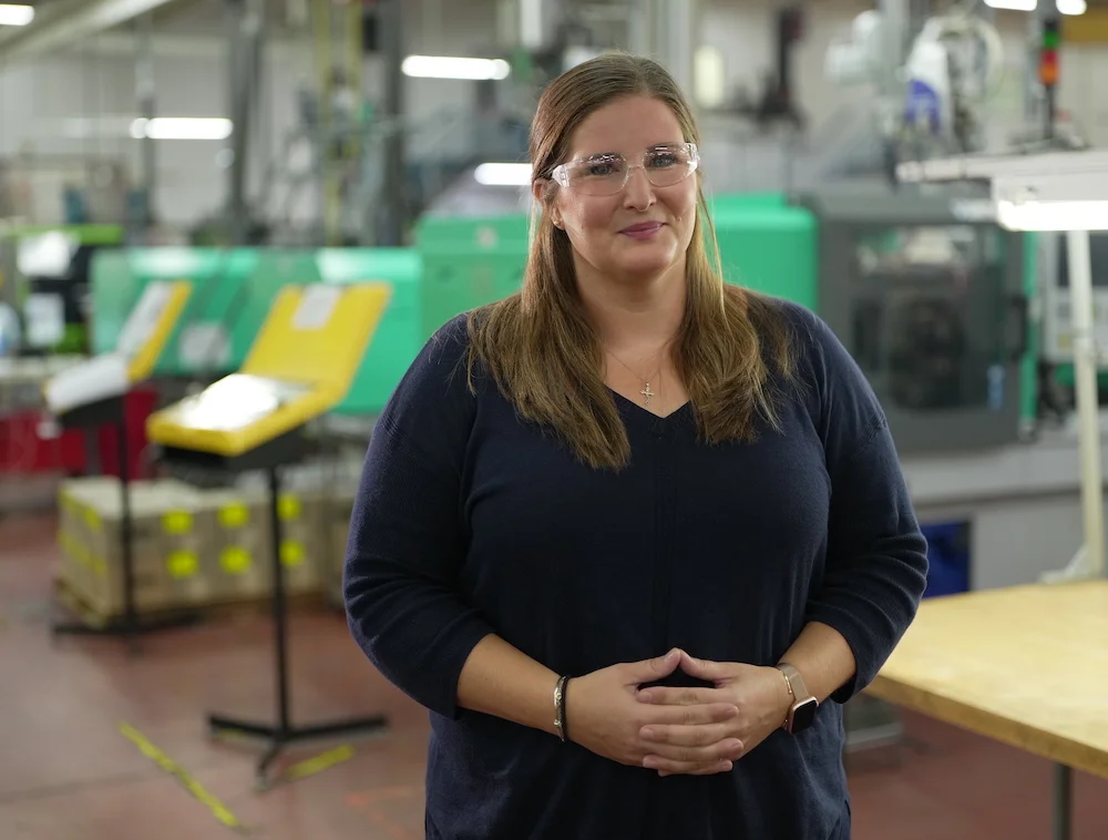 A woman standing in front of a table in a factory