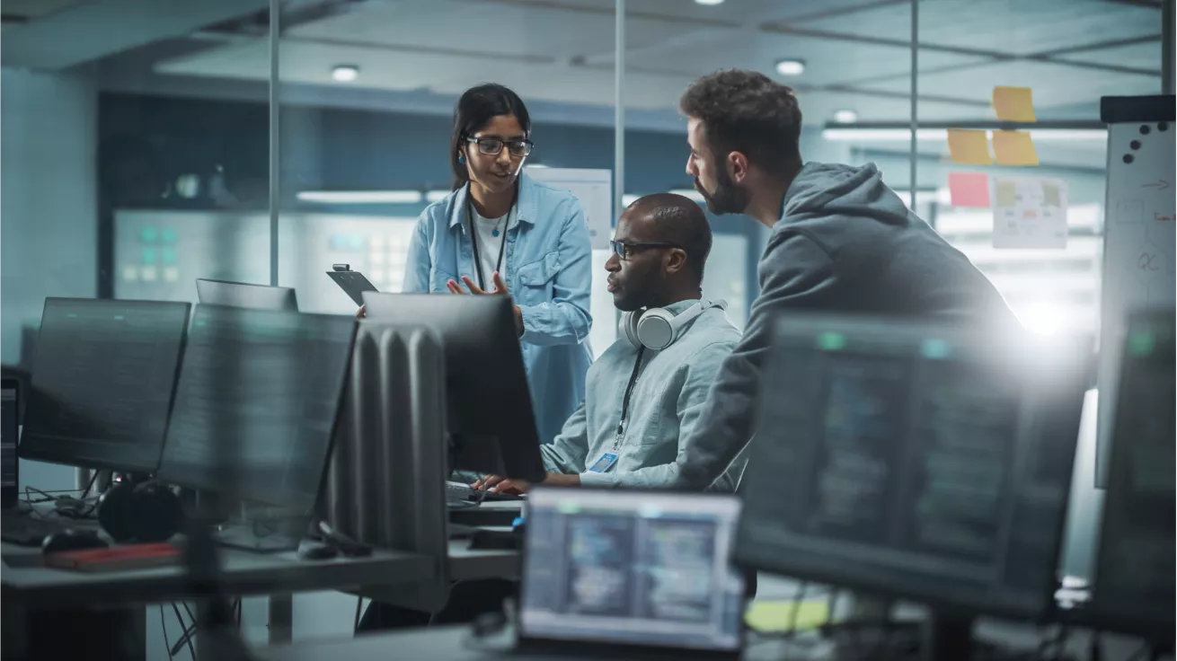 Team sitting around a group of computers